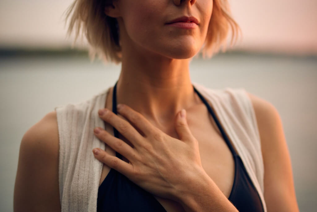 A Woman holding her hand to her chest with an expression of trust and hope.