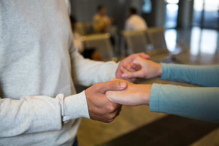 A man and a woman holding hands while standing in a cafe together